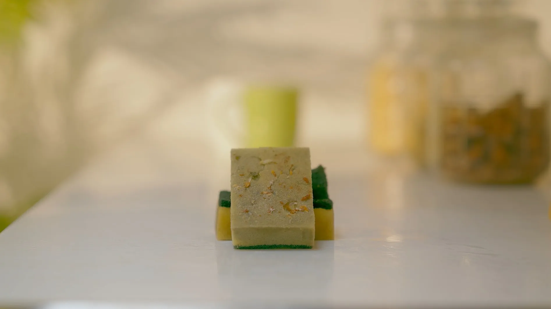 A stained, crumbling foam sponge on the kitchen counter