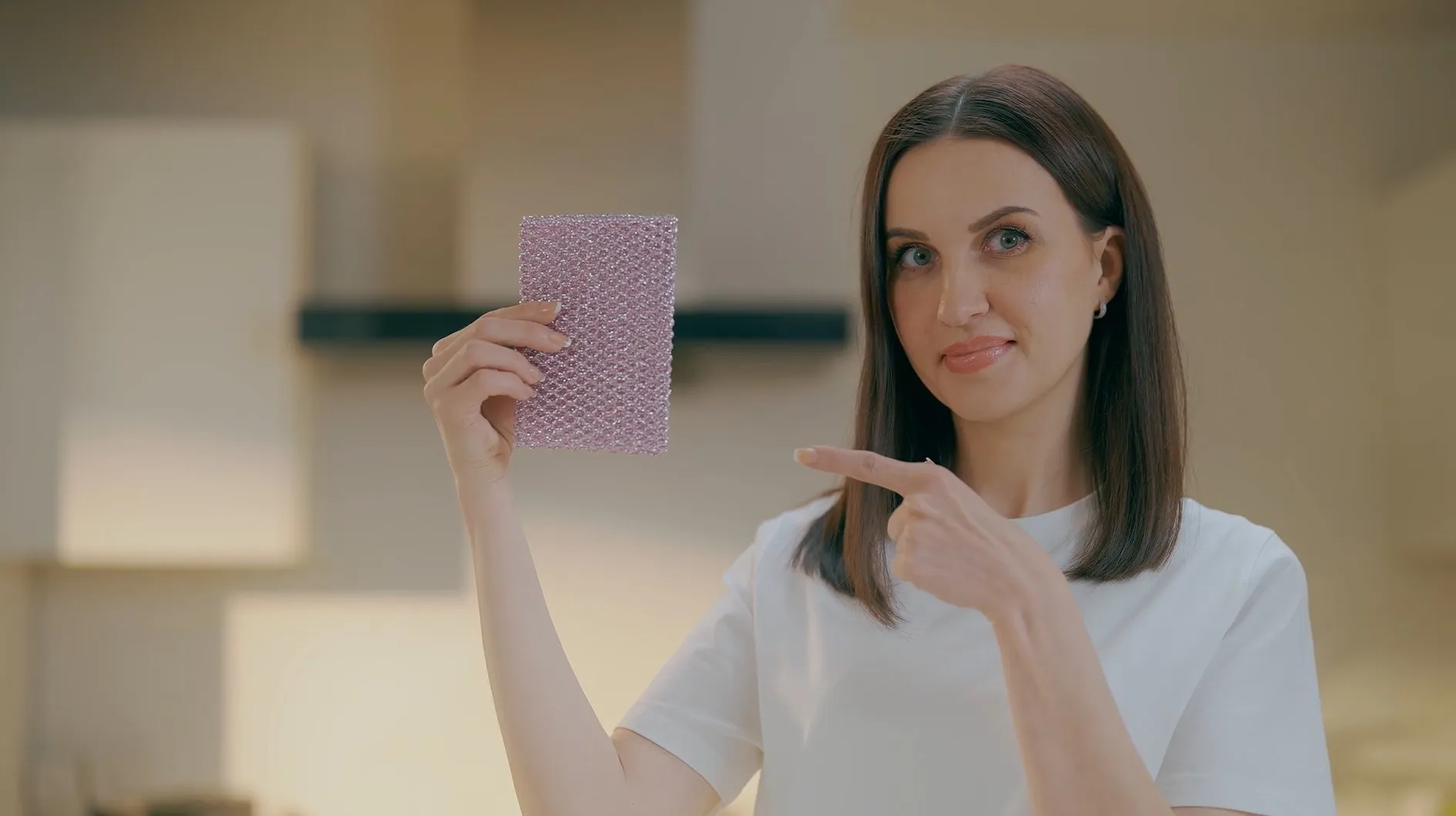 Woman pointing to a pink Non-Scratch Scourer